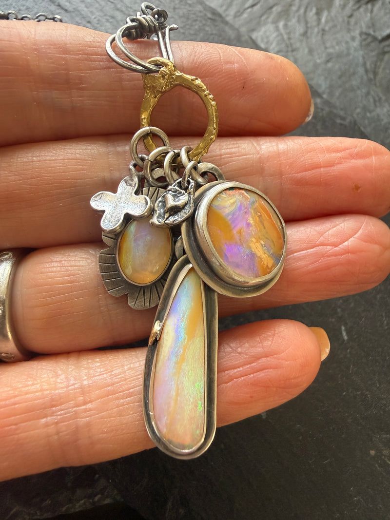 Charm necklace with purple and peach gemstones and a small cross charm